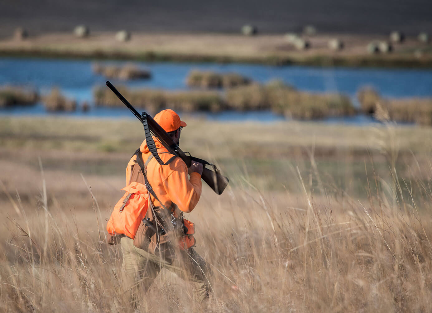 Hunter in field with water in the distance