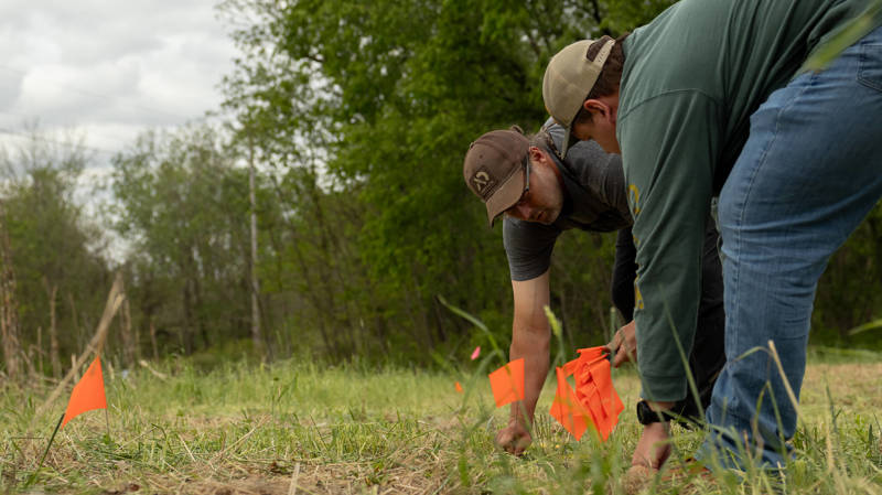 Men crouching in field