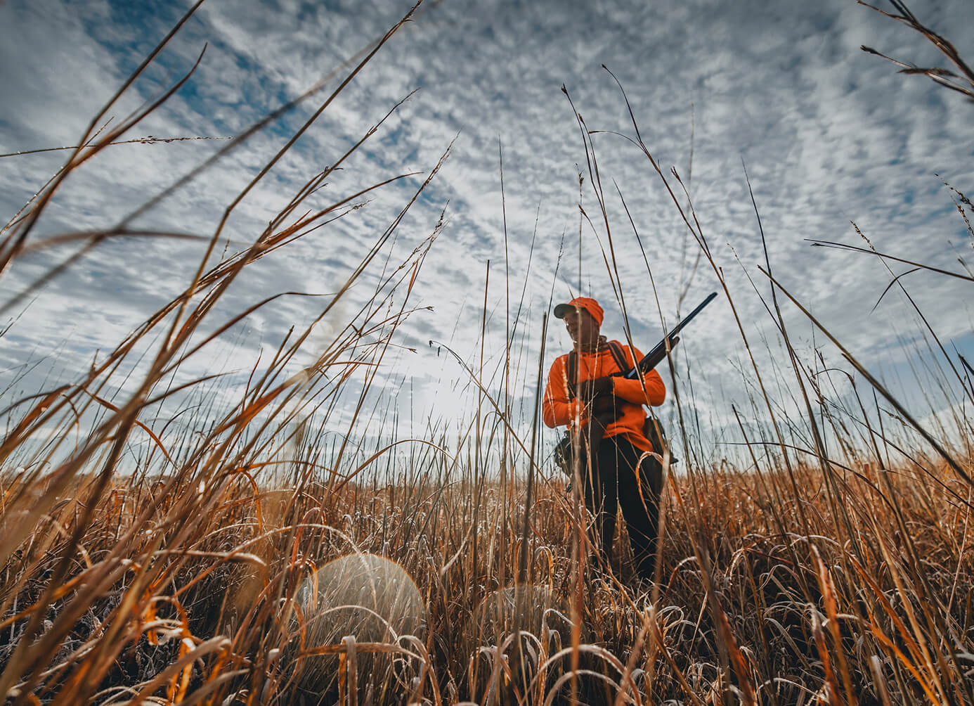 Open Hunting sign in foreground with two blurry hunters in the background